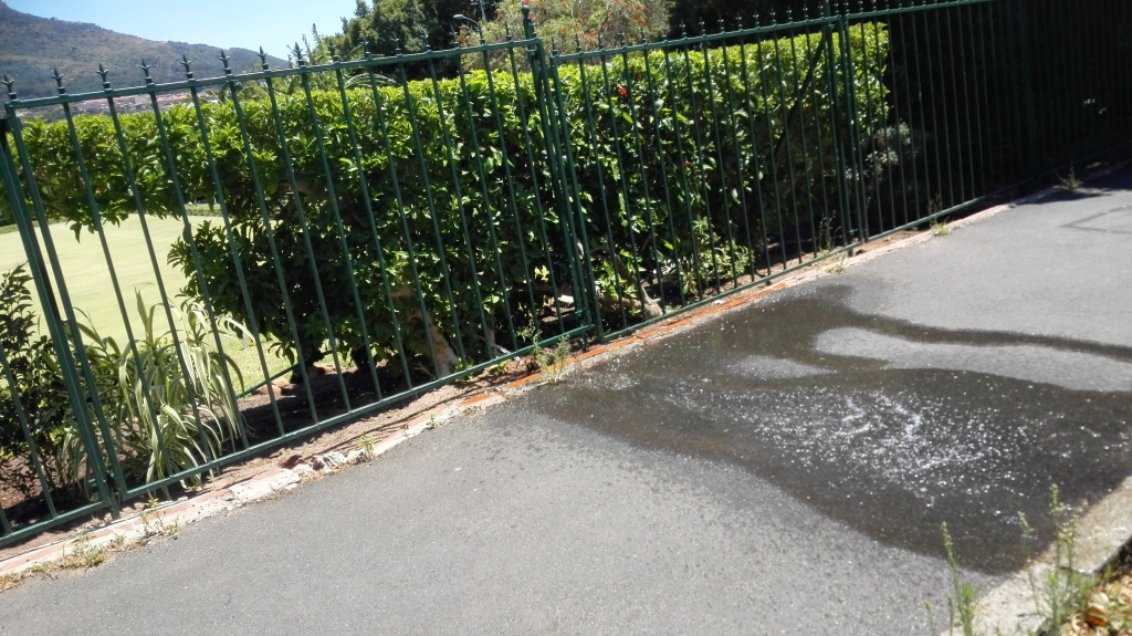 A hosepipe at Kelvin Grove in Cape Town sprays water onto the pavement.